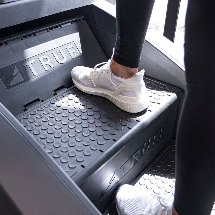 Foot on the deep, textured step of the True Fitness Palisade Climber